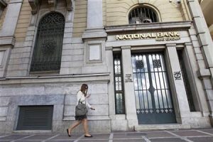 A woman walks outside a National Bank of Greece branch in central Athens April 20, 2012. REUTERS/John Kolesidis